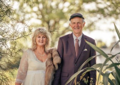 Wedding photo of George & Glenda amidst bushes